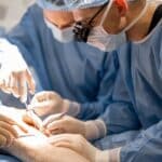 surgeons performing surgical operation on a patient's knee